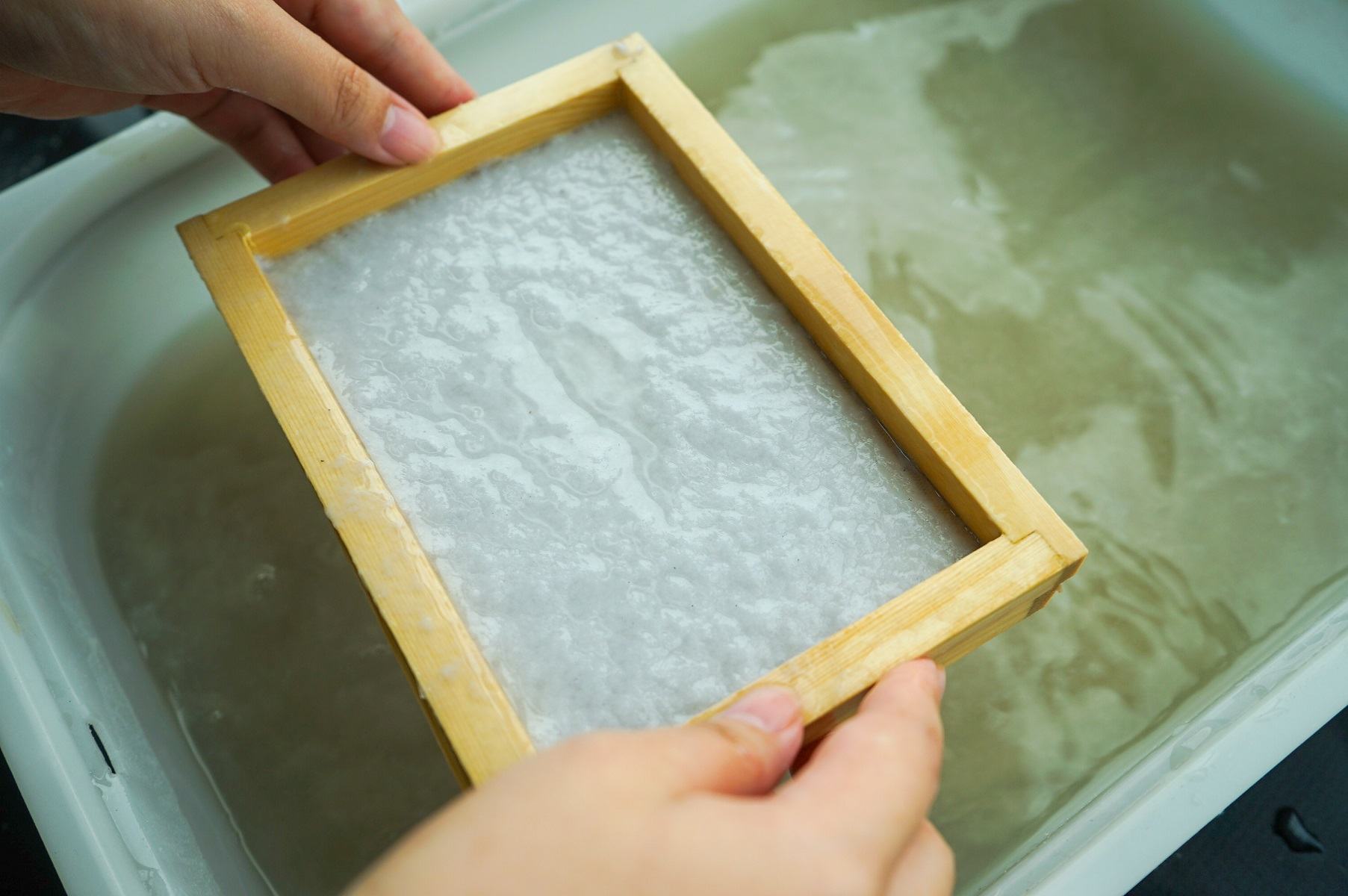Papermaking frame lifting a new sheet from water